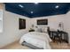Cozy bedroom with blue ceiling accents, modern lighting, and unique wall art at 2529 Mabel Ln, Monroe, NC 28110