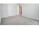 Neutral bedroom with carpeted floors, gray walls, and two white doors offers versatile living space at 2648 Tillman St, Monroe, NC 28112