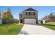 Two story home featuring gray siding and stone accents, a two-car garage, and a well-manicured lawn at 3064 Ora Smith Rd, Lincolnton, NC 28092