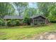 View of backyard with brick and wood home, featuring a charming sunroom and rock garden at 3120 7Th Street Ne Dr, Hickory, NC 28601