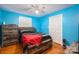Bedroom with wood floors, blue wall, bed, a ceiling fan, a dresser, and closet at 3120 7Th Street Ne Dr, Hickory, NC 28601
