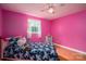 Bedroom with wood floors, pink wall, bed, a ceiling fan, and a single window at 3120 7Th Street Ne Dr, Hickory, NC 28601