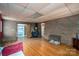 Spacious rec room with hardwood floors, brick accent wall, and wood-burning stove, perfect for relaxation and entertainment at 3120 7Th Street Ne Dr, Hickory, NC 28601
