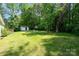 Expansive backyard featuring green grass, a shed, a wooded perimeter and a cozy patio at 321 Woodcrest Dr, York, SC 29745