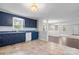 View of the kitchen showcasing blue cabinets, stainless steel appliances, and access to the living and dining areas at 352 18Th Ne Ave, Hickory, NC 28601