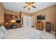 Spacious bedroom includes a ceiling fan, built-in desk, and television at 405 Deer Brush Ln, Waxhaw, NC 28173