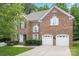 Charming brick home featuring a two-car garage, manicured lawn, and an inviting entryway at 405 Deer Brush Ln, Waxhaw, NC 28173
