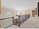 Spacious hallway with carpeted floor and decorative wood and metal railing at 405 Deer Brush Ln, Waxhaw, NC 28173