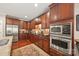 Gourmet kitchen featuring stainless appliances, granite countertops, and custom cherry wood cabinetry at 405 Deer Brush Ln, Waxhaw, NC 28173