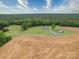 Drone shot of the estate featuring multiple structures, a pond and views of the surrounding farmland and woods at 4115 Jenkins Rd, Marshville, NC 28103