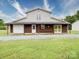 Large barn featuring a garage, covered porch, and ample space for storage or workshop activities at 4115 Jenkins Rd, Marshville, NC 28103
