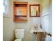 Functional bathroom featuring a wall cabinet, framed mirror, toilet, and unique corner sink with vintage fixtures at 4115 Jenkins Rd, Marshville, NC 28103
