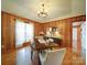 Dining area featuring wood paneling, hardwood floors, a chandelier, and a view through the window at 4115 Jenkins Rd, Marshville, NC 28103