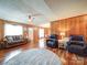 Cozy living room with wood paneling, a comfortable sofa, leather chairs, and a decorative rug at 4115 Jenkins Rd, Marshville, NC 28103