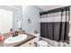 This bathroom features a single sink and a shower/tub with a black and white shower curtain at 4285 Palmer Lloyd Rd, Lancaster, SC 29720