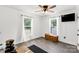 This room features a mounted TV, two windows with natural light, and gray wood flooring at 4285 Palmer Lloyd Rd, Lancaster, SC 29720