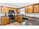 Well-equipped kitchen with oak cabinets, stainless steel appliances, and tile countertops, offering functionality and style at 4285 Palmer Lloyd Rd, Lancaster, SC 29720