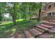 Multi-tiered backyard with stone retaining wall, wood chip steps and lush, mature trees at 4323 Rosecliff Dr, Charlotte, NC 28277