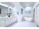 Bright bathroom with marble floors, a soaking tub, and double vanity sinks with gold fixtures at 4323 Rosecliff Dr, Charlotte, NC 28277