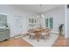Bright dining room featuring hardwood floors, a wooden table, and white shutters on the windows at 4323 Rosecliff Dr, Charlotte, NC 28277
