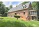 A brick home's exterior features lush greenery and multiple outdoor living spaces with an attached garage at 4323 Rosecliff Dr, Charlotte, NC 28277