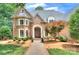 Charming brick home featuring a manicured lawn, mature trees, and an inviting entrance with double doors and a brick walkway at 4323 Rosecliff Dr, Charlotte, NC 28277