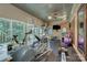 Spacious gym with exercise equipment, large windows, brick accents, and a ceiling fan at 4323 Rosecliff Dr, Charlotte, NC 28277