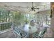 Inviting screened-in porch featuring a cozy dining area with overhead string lights and ceiling fans at 4323 Rosecliff Dr, Charlotte, NC 28277