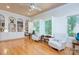 Bright sitting room with hardwood floors, white armchairs, bookshelves, and windows with shutters at 4323 Rosecliff Dr, Charlotte, NC 28277