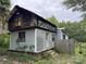 Exterior view of a weathered home with a wooden fence, showing signs of disrepair and overgrown vegetation at 528 Waring Ct # Lot 3, Fort Mill, SC 29707