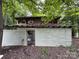 Exterior view of a dilapidated one-story home with wood siding surrounded by trees at 528 Waring Ct # Lot 3, Fort Mill, SC 29707