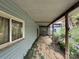 Detailed view of a covered wooden porch of a weathered home, surrounded by overgrown vegetation at 528 Waring Ct # Lot 3, Fort Mill, SC 29707
