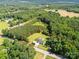 Aerial view of property on large, wooded lot, with tree lined boundary and grassy spaces at 5323 Flat Creek Rd, Heath Springs, SC 29058