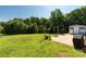 Spacious backyard with a concrete patio, a fire pit, string lights, and bordered by mature trees at 5323 Flat Creek Rd, Heath Springs, SC 29058