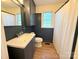 Bathroom offers modern sink and vanity with contrasting navy blue wainscoting at 5323 Flat Creek Rd, Heath Springs, SC 29058