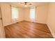 Bright bedroom features wood-look flooring, two windows and ceiling fan at 5323 Flat Creek Rd, Heath Springs, SC 29058