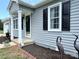 Close-up of the front porch with gray siding, black shutters, and manicured flower beds at 5323 Flat Creek Rd, Heath Springs, SC 29058