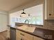 Bright kitchen area with white cabinets and tile backsplash overlooks sunroom at 5323 Flat Creek Rd, Heath Springs, SC 29058