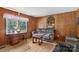 Comfortable living room with light-toned floors, wood paneling, and a window to the outside at 5626 Sandhurst Rd, Hickory, NC 28602