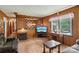 Cozy living room featuring wood paneling, a fireplace, and ample natural light at 5626 Sandhurst Rd, Hickory, NC 28602
