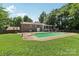 Backyard with a large in-ground pool, diving board, patio, and surrounded by mature trees at 5626 Sandhurst Rd, Hickory, NC 28602