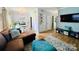 Spacious living room featuring a brown sectional, hardwood floors, and a dining area at 5947 Quail Hollow Rd # A, Charlotte, NC 28210