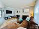 Inviting living room with hardwood floors, fireplace, flat-screen TV, and comfortable brown sectional couch at 5947 Quail Hollow Rd # A, Charlotte, NC 28210