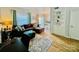 Inviting living room featuring hardwood floors, a leather sectional, built in shelving, and lots of natural light at 5947 Quail Hollow Rd # A, Charlotte, NC 28210
