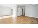 Spacious living room with hardwood floors, built in shelving, and multiple doorways at 5947 Quail Hollow Rd # A, Charlotte, NC 28210