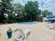 Community pool area with ample seating surrounded by mature trees at 5947 Quail Hollow Rd # A, Charlotte, NC 28210