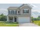 Charming two-story home with neutral siding, black shutters, and a two-car garage at 6328 Busch Way, Midland, NC 28107