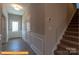 Hallway with staircase, featuring a light-colored wall, white trim, and wood-look flooring at 6328 Busch Way, Midland, NC 28107