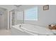 This primary bath features a shower and soaking tub under a window for natural light at 7189 Bovine Ln # 28, Harrisburg, NC 28075