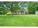 Beautiful home with a well-manicured lawn, mature trees, and a welcoming front porch with columns at 7189 Bovine Ln # 28, Harrisburg, NC 28075